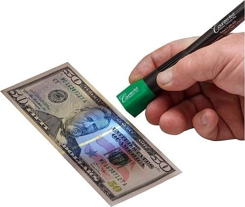 Using a counterfeit detector pen on a US dollar bill.
