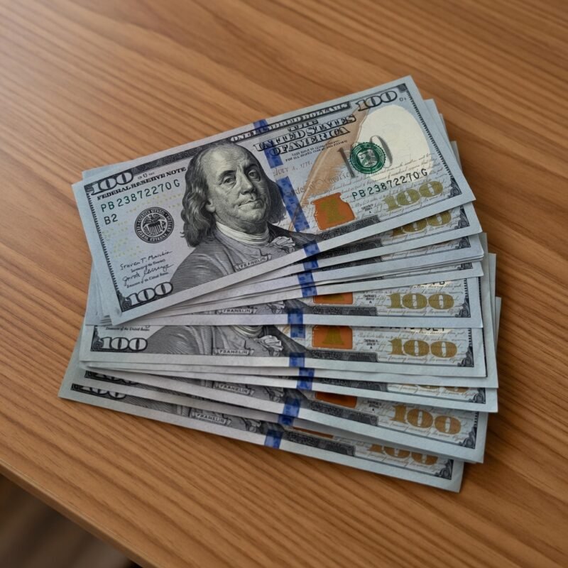 Close-up of high-quality counterfeit $100 bills with Benjamin Franklin portrait, showing realistic security features for sale online.